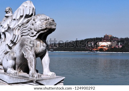 BEIJING - MAR 14:Marble Chinese lion sculpture against the Summer Palace on Kunming Lake  on March 14 2009. The Summer Palace is the best preserved imperial garden in the world.