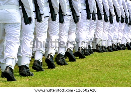 The New Zealand Military Navy wear a plain white uniform, black soldier boots, carry guns and march in a row during an army parade