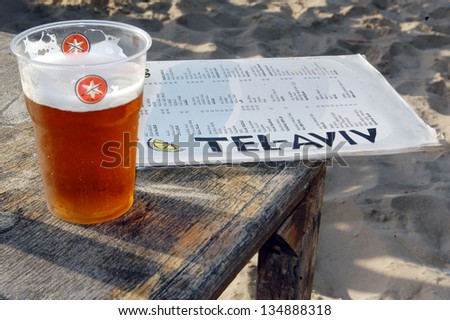 TEL AVIV - MAY 26 2006:Cup of local Israeli beer and Israeli food menu in Tel Aviv beach, Israel.Tel Aviv  rated as a top international destination by Los Angeles Times and the New York Times.