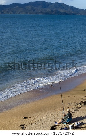 CABLE BAY,NZ-APR 22:Man fishing from the beach on April 22 2013.New Zealand exclusive economic zone covers 4.1 million square kilometers and It\'s the sixth largest zone in the world.