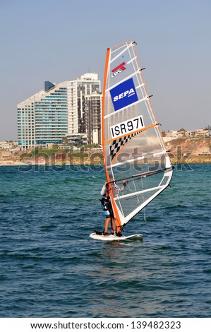 HERZLIYA,ISR- OCT 06:Israeli wind surfer surf along Herzliya Pituah skyline on Oct 06 2009.Windsurfing is one of Israel\'s most successful olympic sports.