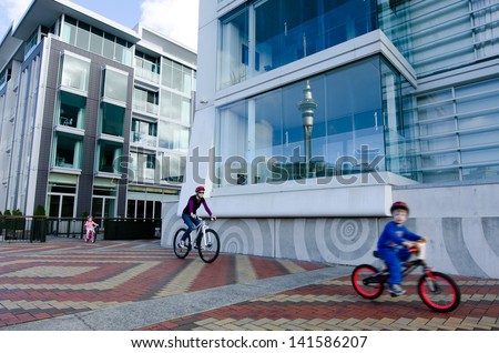 AUCKLAND - MAY 26:Family ride bikes in Auckland Viaduct Harbor Basin on May 26 2013.It\'s a former commercial harbor turned into a development of upscale apartments, office space and restaurants.