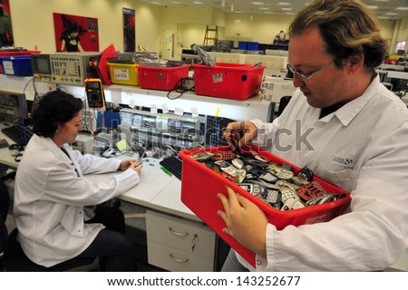 SDEROT, ISR - NOV 26:Cell phone recycling plant technician works on crapped mobile phones on Nov 26 2008.Mobile phoneÃ?Â??s shelf life is only about 18 months for the average consumer.