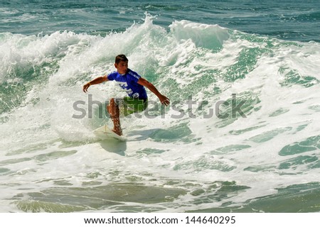 ASHKELON - OCT 09: Wave surfer surfing wave at sea on October 09 2010 in Ashkelon, Israel.It originated by Polynesian people and was first discovered by Captain Cook in 1778.