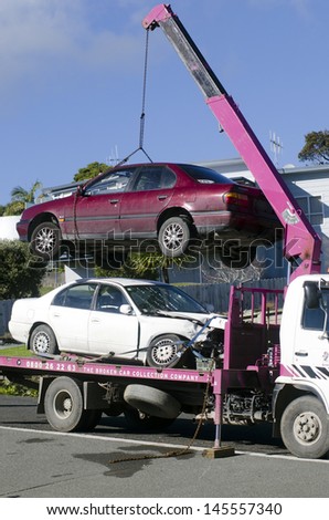 CABLE BAY,NZ - JULY 01:Man towing damaged car on tow truck on July 01 2013.In Australia exists a Tow Truck Act, and tow trucks are identified by number plates ending in \