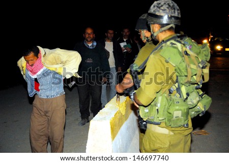 WEST BANK, ISR - MAR 05:Israeli soldiers checks Palestinians on Mar 5, 2008.Since the 90s Israel has created hundreds of permanent roadblocks and checkpoints to prevent violence and terror.