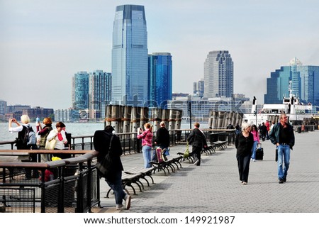 NEW YORK CITY - OCT 09 2010:Visitors looks at Jersey City from Battery Park. It\'s an important transportation terminus, distribution and manufacturing center for the Port of New York and New Jersey.