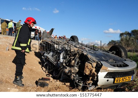 ASHKELON,ISR - FEB 01:Firefighter in a deadly car accident scene on Feb 01 2009.According to the World Health Organization:1.2M people are killed in traffic accidents each year around the world