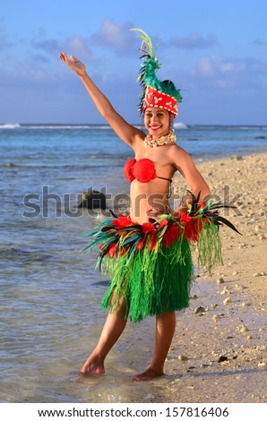Portrait of Polynesian Pacific Island Tahitian female dancer in colorful costume dancing on tropical beach.