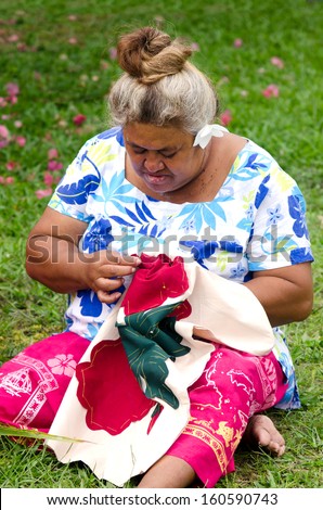Portrait of Polynesian Pacific Island Tahitian mature female sewing Tivaivai outside her home in Aitutaki lagoon Cook Islands.