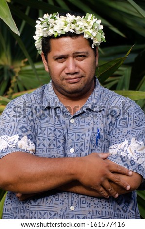 Portrait of Polynesian Pacific Island Tahitian mature male wearing exotic flowers top bouquet smile out side his home garden in Aitutaki lagoon Cook Islands.