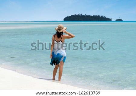 Young woman relaxing on Aitutaki Lagoon Cook Islands. Concept photo of women freedom, travel, vacation ,happy, happiness, solo, alone, single, fun.