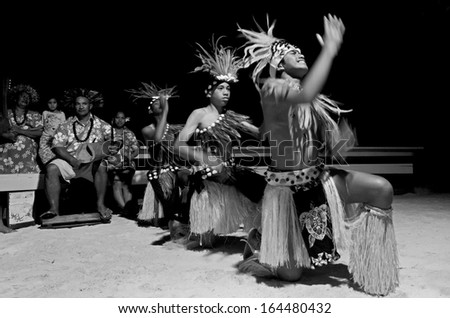 AITUTAKI - SEP 19:Polynesian Pacific Island Tahitian male dancers in costume dancing on Sept 19 2013 on tropical beach in Aitutaki lagoon Cook Islands. (BW)