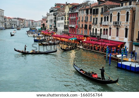 VENICE, ITALY - APR 30 2011:The Grand Canal in Venice with gondoliers rowing gondolas.There are only 400 licensed Gondolas operating in Venice today only 4 Gondolier licenses are issued annually.