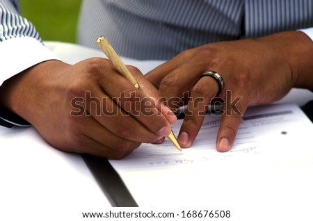 Groom signing marriage license or wedding contract. close-up