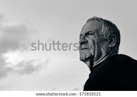 Portrait of handsome tough mature man (70s) against sky background. (BW) copy space Concept photo of getting old , future, retirement health and lifestyle.