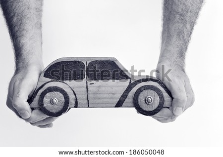 Hands and toy car isolated on white background - copy space.Concept photo of car business, car Insurance, auto dealership,car rental ,safe driving ,buying, renting, fuel, service and repair costs (BW)