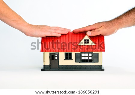Couple touch a toy house isolated on white background - copy space.Concept photo of real estate business, home  Insurance, house rental,buying, renting, mortgage, finance,service and repair costs