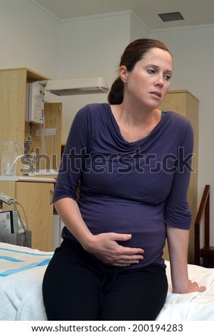 Pregnant woman having contraction in birthing suite of Maternity Hospital.