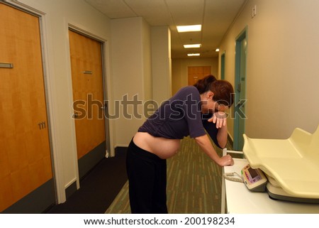 AUCKLAND - JUNE 07 2014:Pregnant woman having contraction in birthing suite of Maternity Hospital.In the 1960s, Igor Tjarkovsky,swimming instructor and midwife, popularized water birth in Russia.