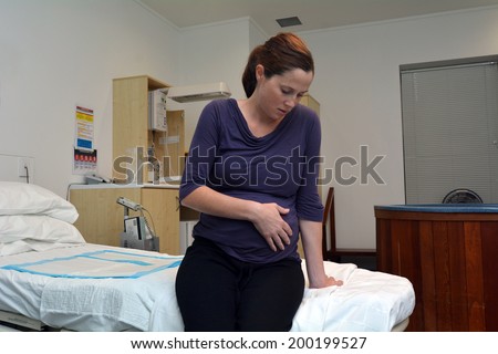AUCKLAND - JUNE 07 2014:Pregnant woman having contraction in birthing suite of Maternity Hospital.Prelabour the contractions are generally sporadic or irregular and rarely less than 5-10 minutes apart