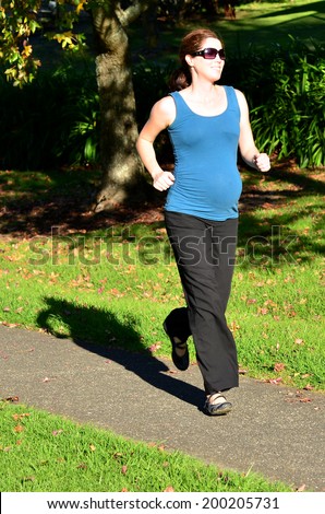 Pregnant woman run exercise during pregnancy outdoor at the park. Concept photo of women healthy life style and health care. copyspace