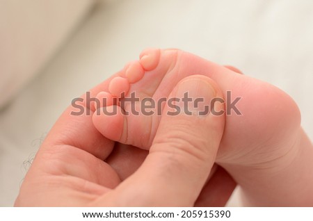 Hand of a young father touch his newborn baby foot (4 week old). copyspace,  Concept photo of newborn, baby, mother, motherhood, parenting and lifestyle