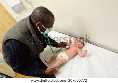 AUCKLAND - JULY 23 2014:Doctor checks the heart beats of a newborn baby (Naomi Ben Ari age 0) .The avarage baby heart beats is 115 beats per minute at 1 year old.