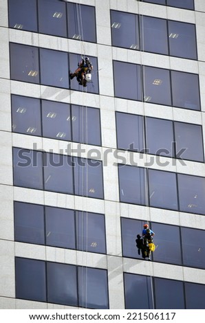 BRISBANE - SEP 25 2014:Window cleaners work on high rise building.Window cleaning is considered one of the most dangerous job in the world.Several window cleaners die each year and many are injured