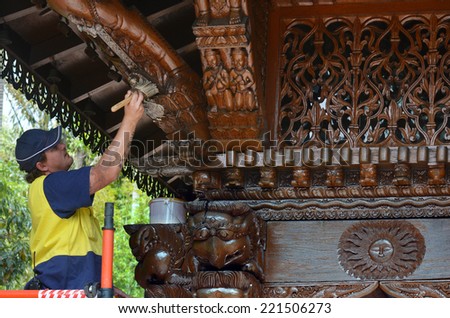 BRISBANE - SEP 25 2014:Worker varnish a wooden wall of Nepal Peace Pagoda in Brisbane, Australia.It is one of the most significant heritage items in Brisbane from Brisbane World Expo \'88 site.