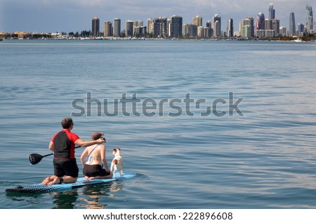 GOLD COAST - SEP 27 2014:Couple on stand up paddling in Surfers Paradise.It\'s one of Australia\'s iconic coastal tourist destinations, drawing 10 million tourists every year from all over the world.