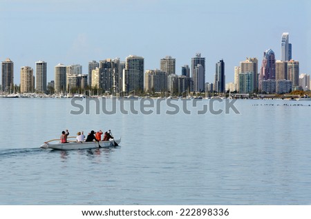 GOLD COAST - SEP 27 2014:People row a canoe under Surfers Paradise Skyline.It\'s one of Australia\'s iconic coastal tourist destinations drawing 10 million tourists every year from all over the world.