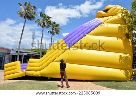GOLD COAST - OCT 19 2014:Worker inflate slide bouncy Castle.In 2001 U.S. Consumer Product Safety Commission outline the dangers and recommended safety precautions for operating an inflatable structure