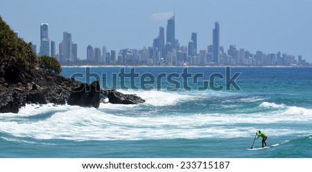 SURFERS PARADISE - NOV 09 2014:Man on stand up paddling in Surfers Paradise.It one of Australia\'s iconic coastal tourist destinations, drawing 10 million tourists every year from all over the world.