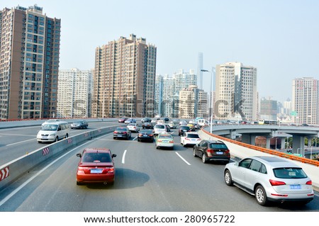SHANGHAI, CN - MAR 15 2015:Traffic against Shanghai cityscape.Shanghai is the largest Chinese city by population and the largest city proper by population in the world with over 2 million vehicles.