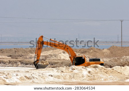 EIN BOKEK, ISR - APR 30 2015:Dead Sea Works bulldozer dig salt.It's the world's 4th largest potash products plant blamed by conservationists for polluting the Dead Sea environment and it's evaporation