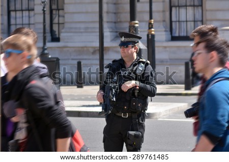 LONDON - MAY 12 2015:British counter terror police man on guard duty.Since Jan 2015 Police across Britain have been put on high alert and warned that they may be targeted in terror attacks