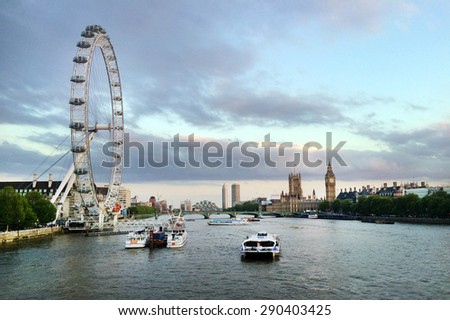 LONDON - MAY 12 2015:Thames river cruise boats sail under the London Eye in London, UK.In 2014, Coca-Cola signed an agreement to sponsor the London Eye for two years, starting from January 2015.