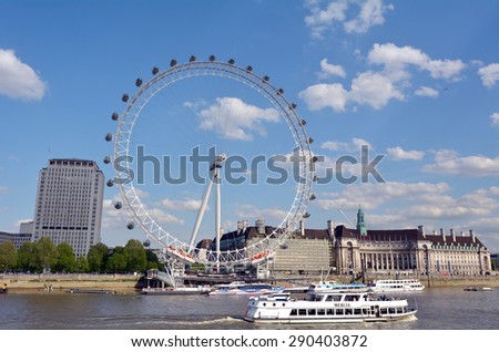 LONDON - MAY 12 2015:Thames river cruise boats sail under the London Eye in London, UK.In 2014, Coca-Cola signed an agreement to sponsor the London Eye for two years, starting from January 2015.