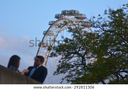 LONDON, UK - MAY 15 2015:Romantic couple under London Eye in London, UK.London Eye is on of the top 5 of most romantic places in London.
