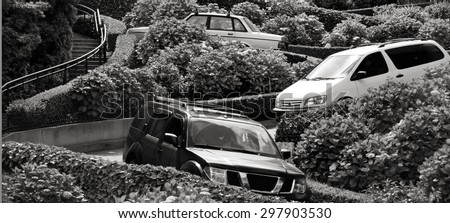 SAN FRANCISCO - MAY 20 2015:Cars drive down Lombard Street switchback.Lombard Street is known for the one-way block on Russian Hill where 8 sharp turns make it the most crooked street in the world.