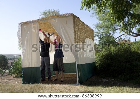 Jewish people decorating the family Sukkah for the Jewish festival of Sukkot. A Sukkah is a temporary structure where meals are taken for the week.