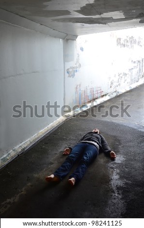 Crime scene concept photo of a murder victim woman lying dead on the ground of a tunnel.Concept photo of murder and crime