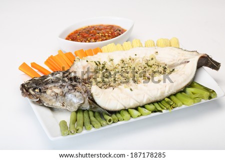 Steamed fish topped with spicy herb on white dish