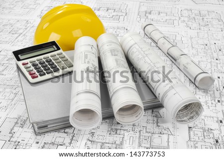 Yellow helmet, calculator, grey folder document and project drawings
