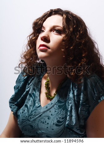 A portrait about a pretty lady with white skin and long brown wavy hair who wears a nice dress and she is thinking