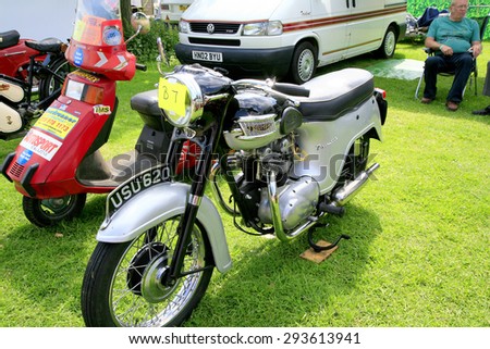 ELVASTON, DERBYSHIRE, UK. JULY 04, 2015. A vintage 1961 Triumph T 100A motorcycle and a Vintage 1983 Honda NV50 stream Moped on display at the country steam rally at Elvaston in Derbyshire, UK.