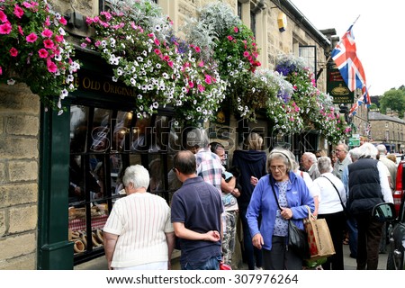 BAKEWELL, DERBYSHIRE, UK. AUGUST 17, 2015. The original pudding shop decoratated with baskets of flowers on the high street at Bakewell in Derbyshire, UK.