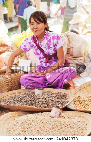 Heho, Myanmar - March 02, 2011 : Young Burmese woman selling nuts and beans at five-day market while sitting on the ground