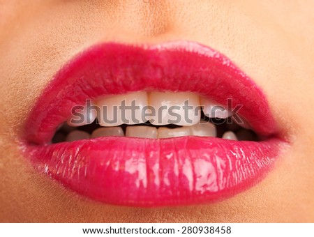 Attractive woman lips in toothy smile with red lipstick, close up